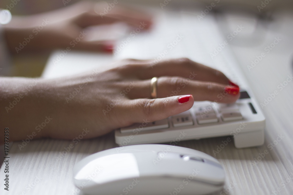 Fototapeta premium Female hands typing on white computer keyboard
