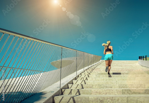 Blonde woman running training near the modern architecture build