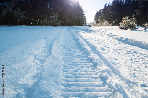 Close-up of a snowmobile trace on snow and sun