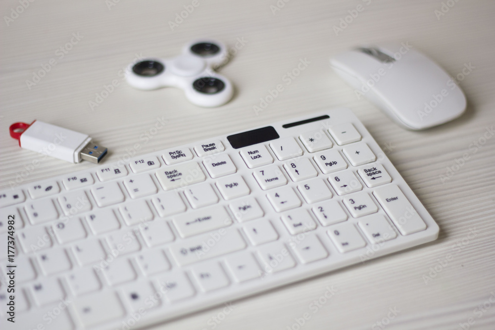 white computer mouse, spinner, flash card and keyboard on a white table, business concept white computer mouse, spinner, flash card and keyboard on a white table, business concept