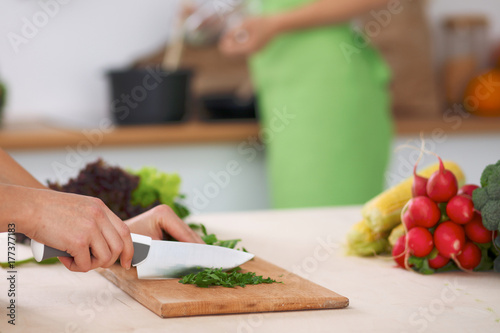 Close-up of human hands cooking vegetables salad in kitchen. Healthy meal and vegetarian concept