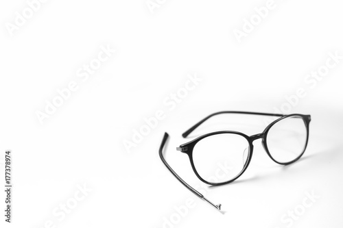 Old glasses on broken legs on white background,selective focus
