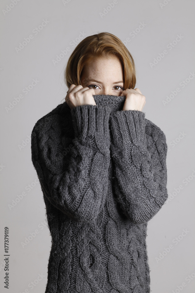girl with red hair hiding behind collar of sweater girl with red hair hiding behind collar of sweater