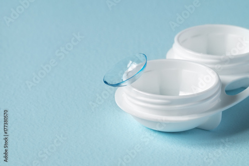 Container for contact lenses, contact lenses, on blue background. Close-up