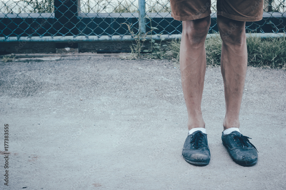 A man legs wearing black canvas shoes and brown pants standing on concrete  ground with copy space in Japanese tone style. Fashion divided into shorts  sneakers. Photos | Adobe Stock