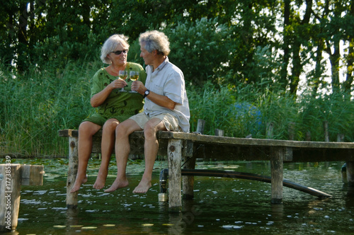 Happy Senior Couple on Vacation in Nature, enjoying a glass of wine and their retirement