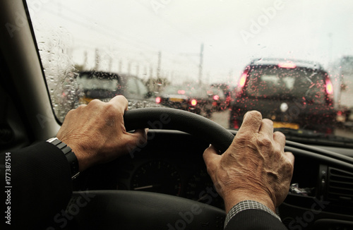 Canvastavla Mature mans hands clasping the Steering Wheel in his car during a rush hour Traf