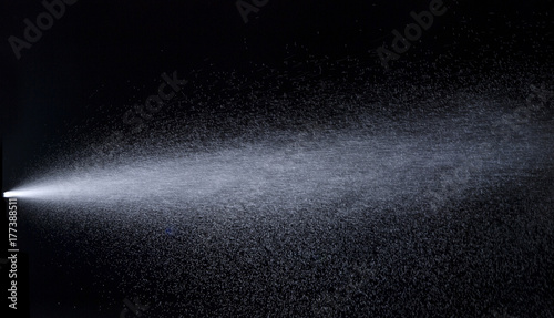 Water jet spraying on black background