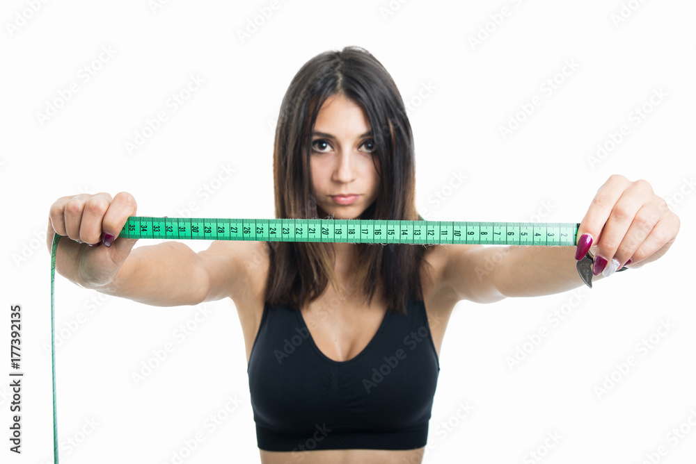 Portrait of fit girl holding up measuring tape Portrait of fit girl holding up measuring tape