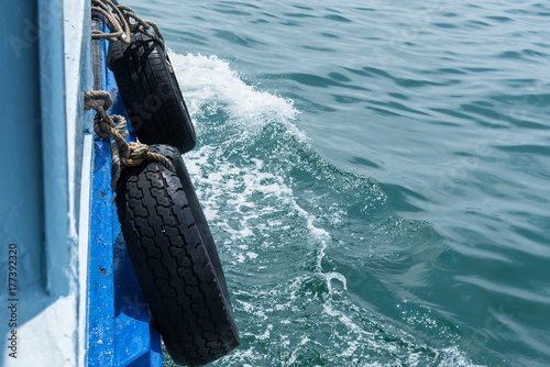 Rubber old wheel hanging in beside of cushioning to ship.