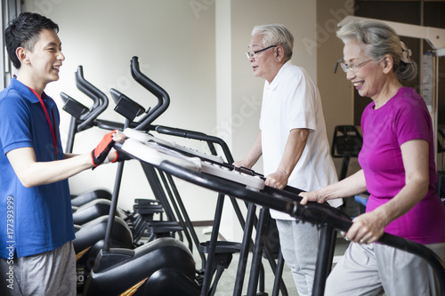An old couple enjoying running machines with trainers