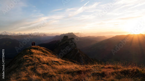two persons in evening sunlight on a mountain in the alps