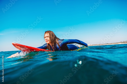 Surfer girl on surfboard. Woman in ocean during surfing.