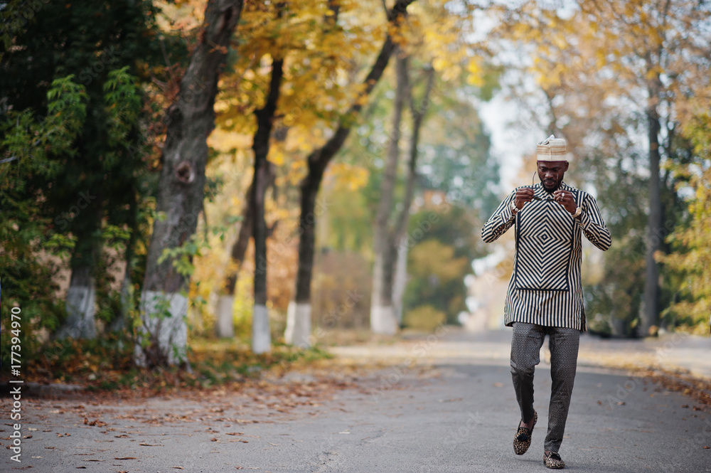 Portrait of stylish black african american man at hat and sunglasses against sunny autumn fall background. Rich people in africa at traditional dress. Portrait of stylish black african american man at hat and sunglasses against sunny autumn fall background. Rich people in africa at traditional dress.
