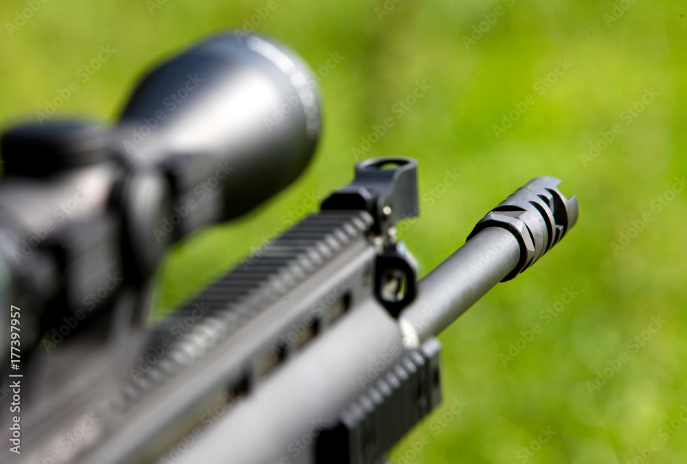 Black MilitaryStyle Rifle Aimed Forward With Blurred Background And