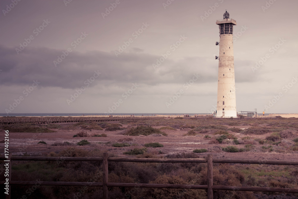 Morro Jable lighthouse in Fuerteventura, Canary islands, Spain. With copy space. Vacation, relaxing background or wallpaper in antique pink filter.