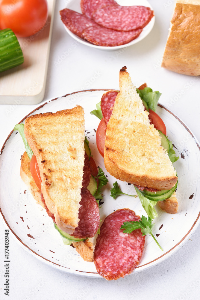 Sandwiches with salami, tomatoes, cucumber and lettuce
