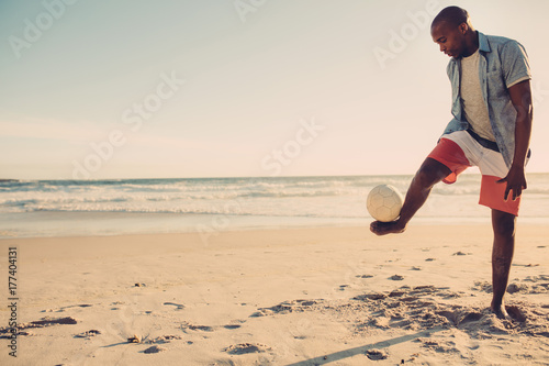 Man playing with football along the beach