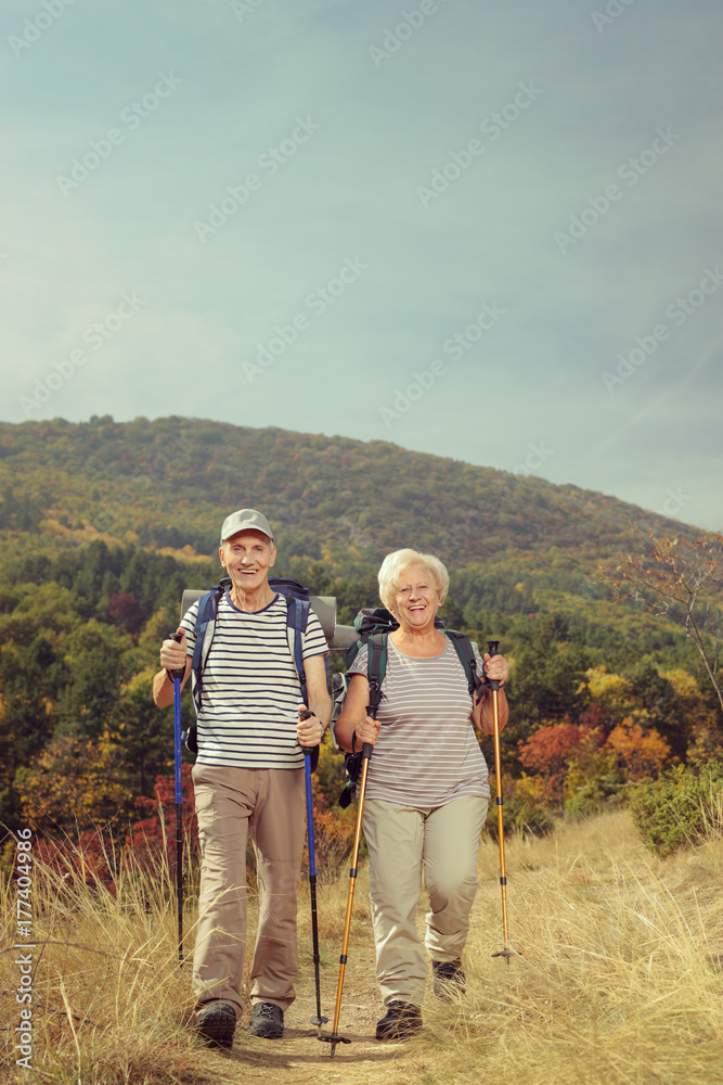 Two elderly hikers walking outside