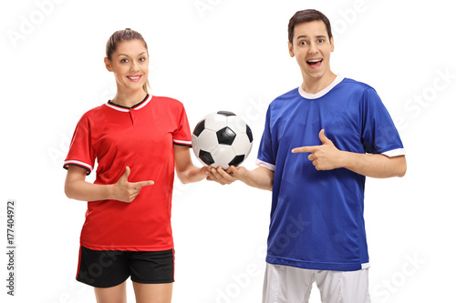 Female footballer and a male footballer pointing