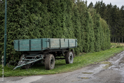 green trailer parked on a forest path near the village © Vladimira