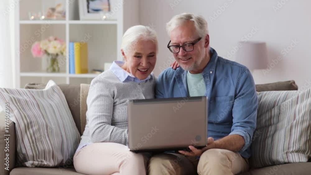 senior couple having video chat on laptop at home senior couple having video chat on laptop at home