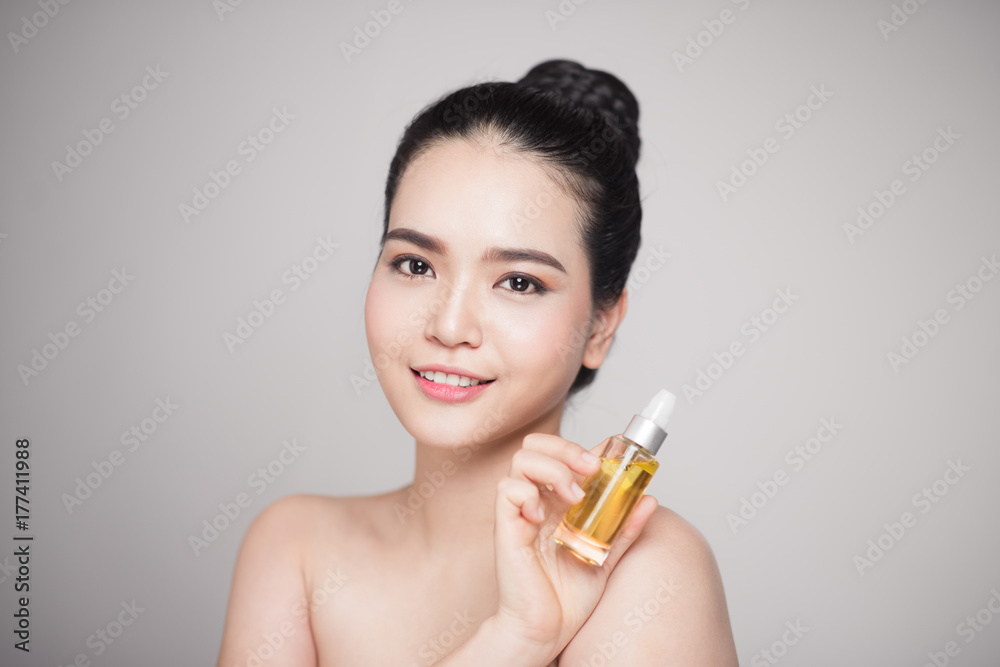 Beauty concept. Asian pretty woman with perfect skin holding oil bottle Beauty concept. Asian pretty woman with perfect skin holding oil bottle