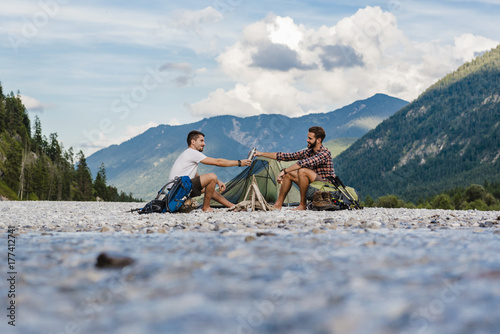 Germany, Bavaria, two hikers camping on gravel bank photo