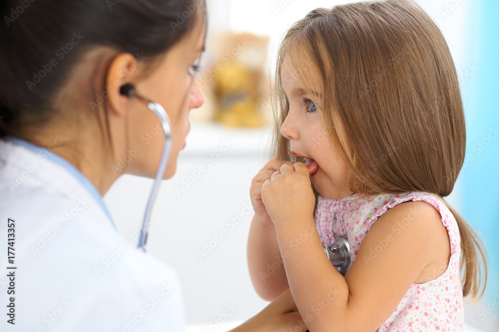 Doctor examining a little girl by stethoscope Doctor examining a little girl by stethoscope