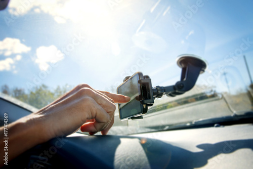 young man using a smpartphone while driving a car