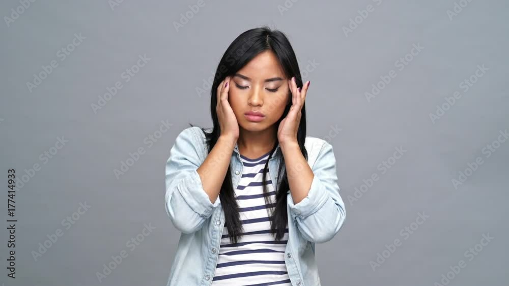 Young sad asian woman isolated feeling pain in neck Young sad asian woman isolated feeling pain in neck