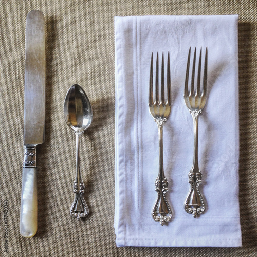 Beautiful silverware on a neutral tablecloth.