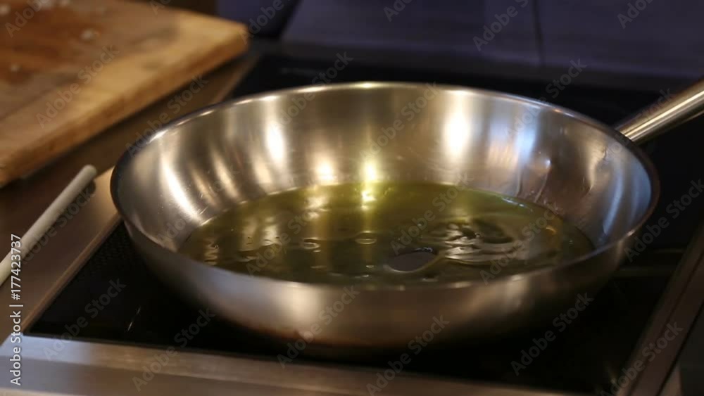 Drizzle Olive Oil in Frying Pan for Cooking Close Up. a close up of someone pouring olive oil into a frying pan on a stove preparing to cook
Drizzle Olive Oil in Frying Pan for Cooking Close Up. a close up of someone pouring olive oil into a frying pan on a stove preparing to cook