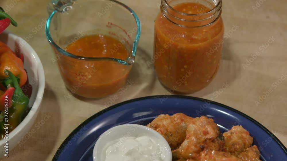 Move Back Over Top Hot Sauce and Chicken Wings Medium. a medium view moving back over top of hot sauce in a container and move back over chicken wings on a plate
Move Back Over Top Hot Sauce and Chicken Wings Medium. a medium view moving back over top of hot sauce in a container and move back over chicken wings on a plate