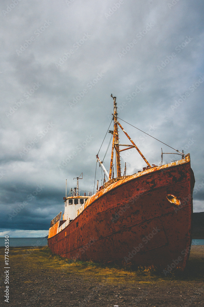 A rusty ship wreck stranded at a beach A rusty ship wreck stranded at a beach