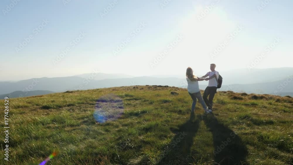 Romantic couple holding hands and spinning around on the meadow. Romantic couple holding hands and spinning around on the meadow.