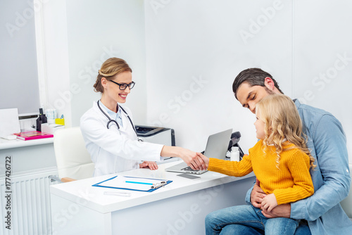 doctor shaking hand of little girl