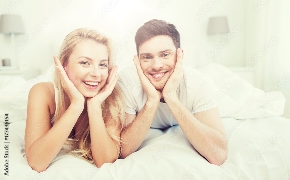 happy couple lying in bed at home