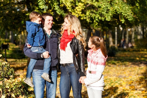 A happy family having fun in the park in autumn. Family, love, happiness concept. Family of four