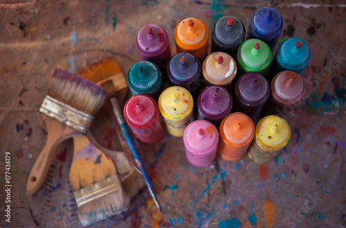 Overhead shot of many bottles of paint and brushes