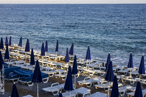 People enjoy a beautiful summer sunset in the Opera Plage, the oldes beach of the French city of Nice photo