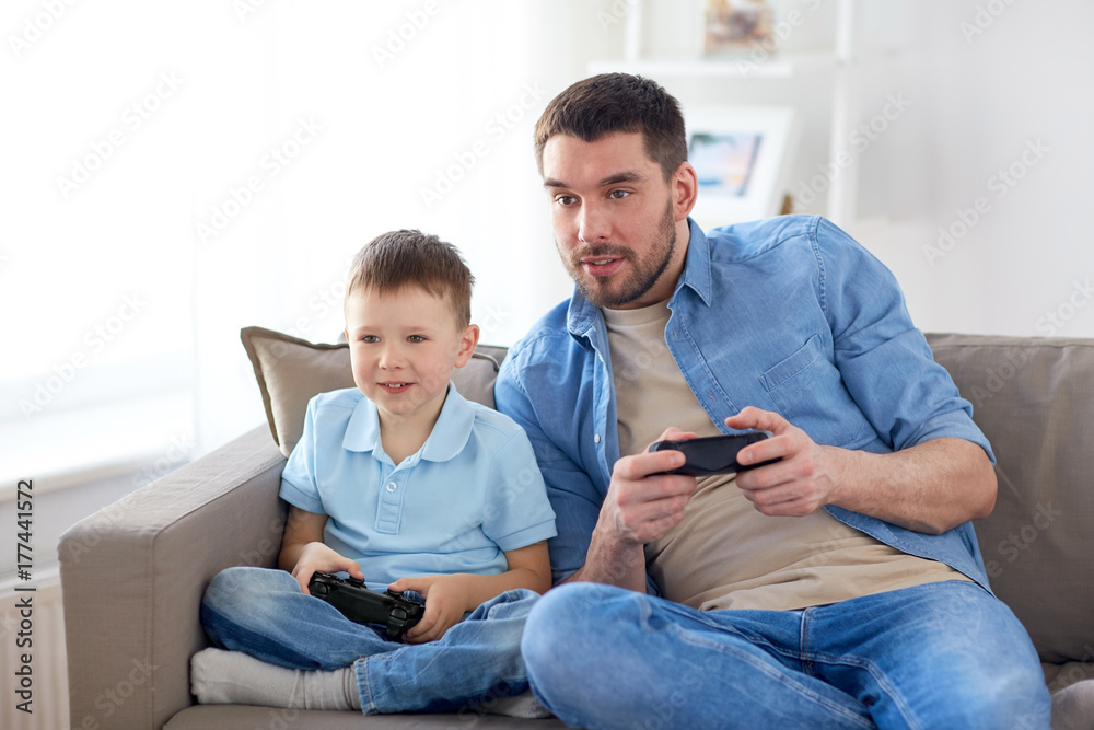 father and son playing video game at home father and son playing video game at home