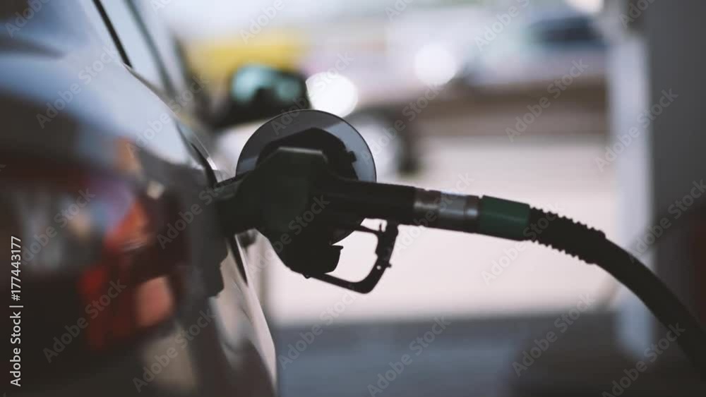 Pumping gasoline fuel in car at gas station Pumping gasoline fuel in car at gas station