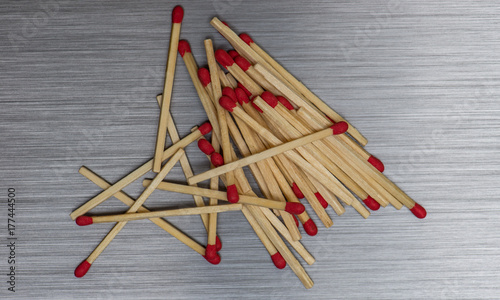 Obraz na plátně Wooden Matchsticks spilled out on brushed metal background texture