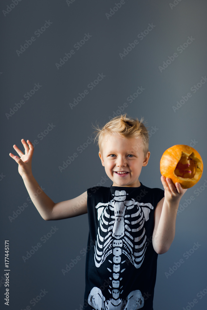 A cute young boy dressed up as a scary skeleton for halloween A cute young boy dressed up as a scary skeleton for halloween
