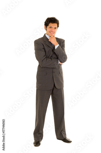 Full length of a handsome young man with curly hair, wearing a nice suit, and posing in a white background