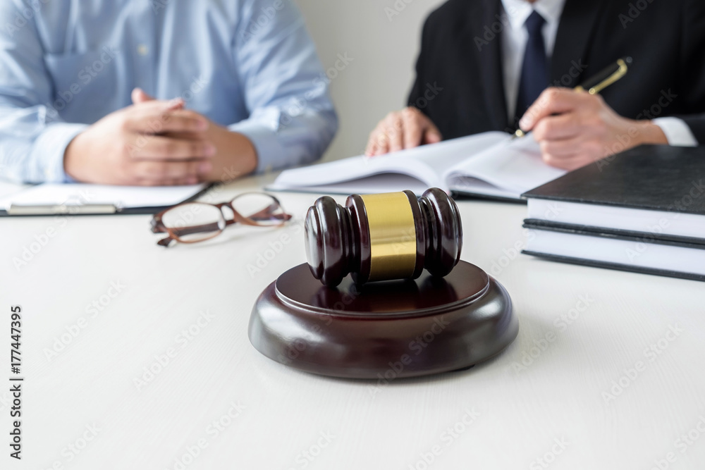 Close up of gavel, Male lawyer or judge Consult with client and working with Law books, report the case on table in modern office, Law and justice concept Close up of gavel, Male lawyer or judge Consult with client and working with Law books, report the case on table in modern office, Law and justice concept
