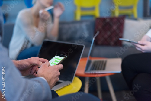 Young casual businessman using smartphone