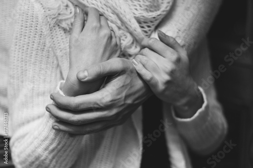 The man gently hugs his girlfriend. Lovers' hands