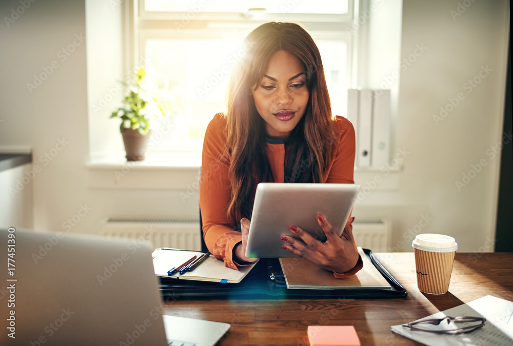 Fototapeta premium Young woman working with a tablet in her home office